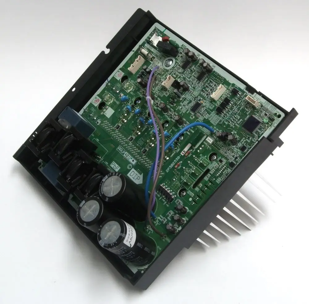 Grüne elektronische Platine mit mehreren Bauteilen, darunter Kondensatoren und Kühlkörper, als Bestandteil von Daikin Klimaanlagen.